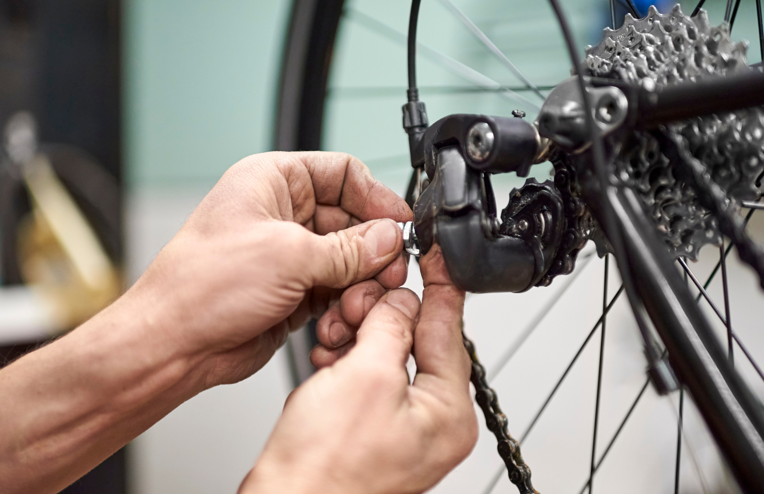Fahrrad Mechaniker mit Fahrradkette in der Hand © Shutterstock / Carolina Jaramillo
